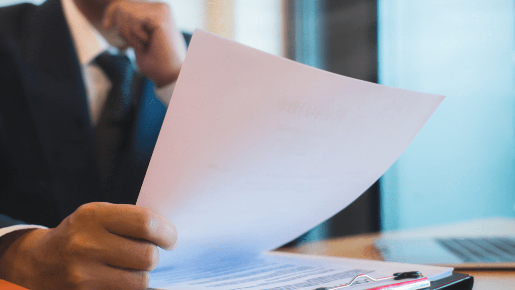 A person sitting at a table with a laptop and papers