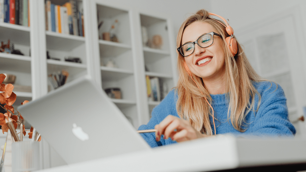 A smiling person working on a laptop