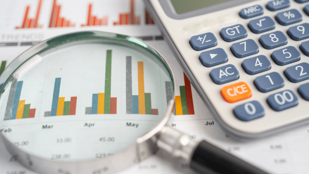 a magnifying glass and calculator on top of financial documents