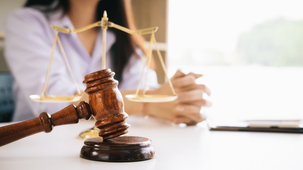 judge's gavel and scales of justice on a table in a courtroom