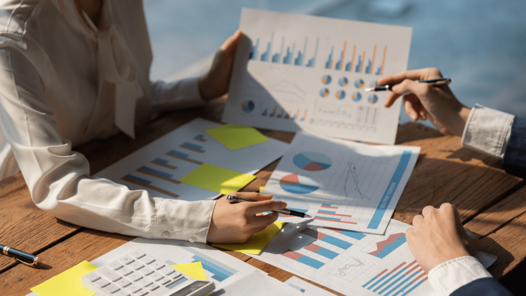 a group of business people at a table with graphs and papers