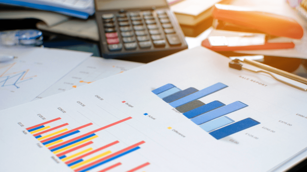 a magnifying glass and calculator on top of financial documents