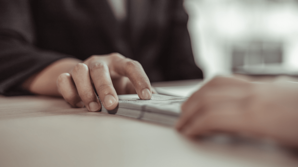 a person handing money to another person at a desk