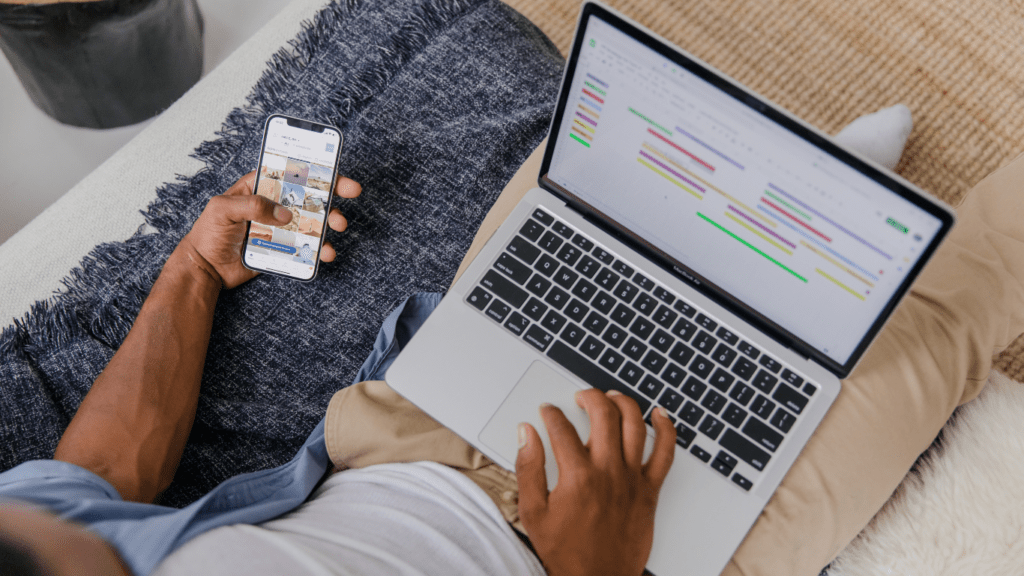 a person sitting on a couch with a laptop and cell phone