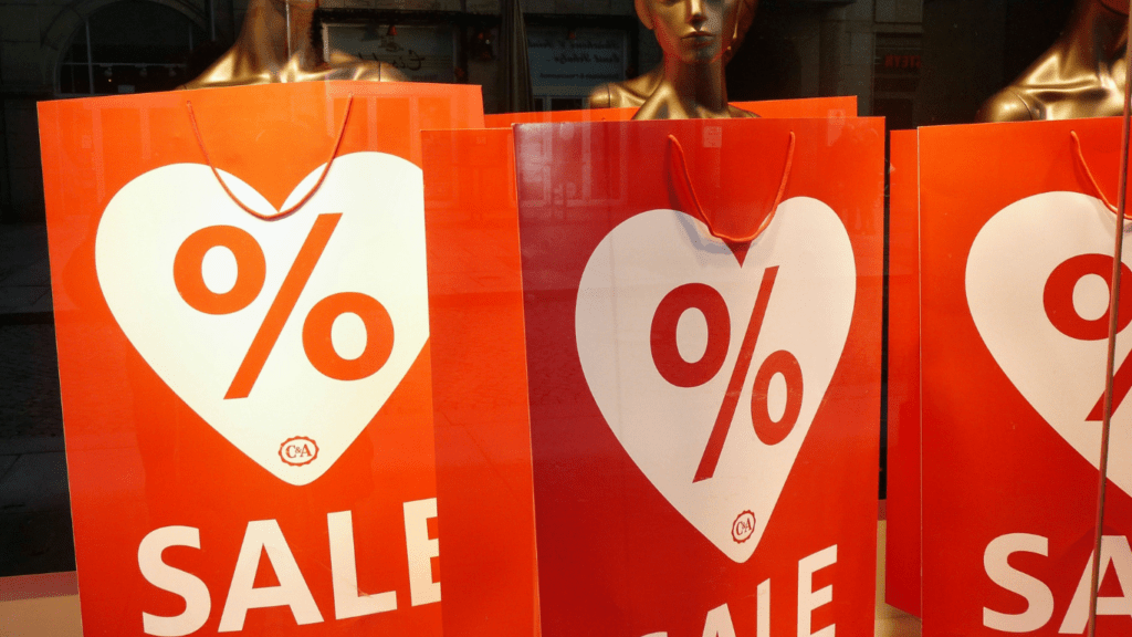 a sale sign is reflected in the window of a store